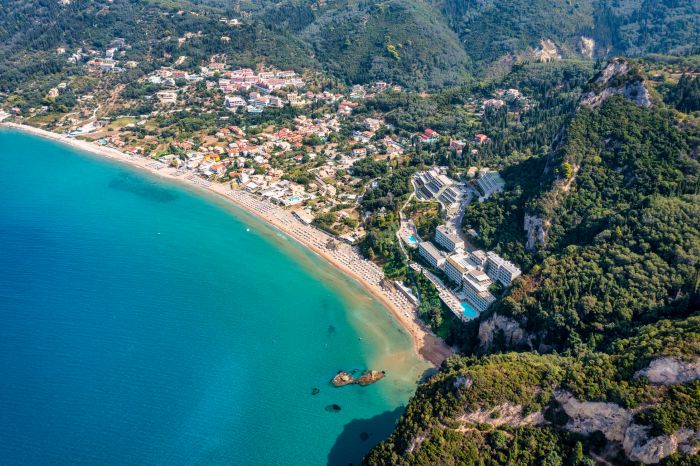 Panoramic view of the Agios Gordios beach, sandy seashore with beach umbrellas and deck chairs