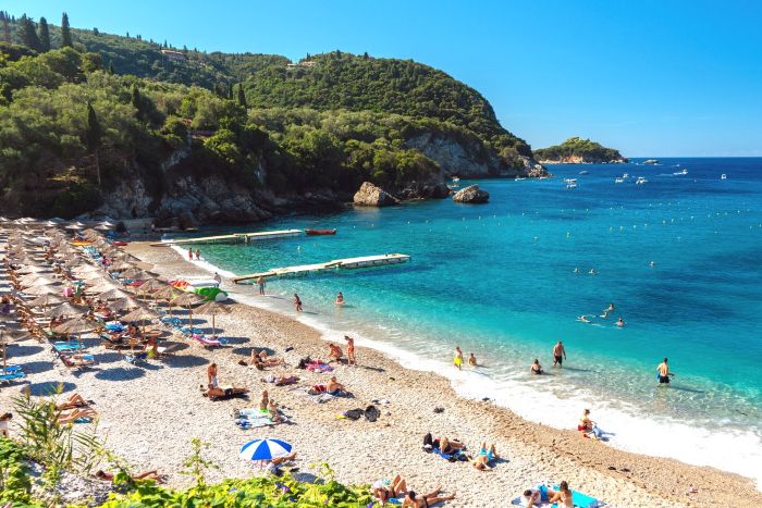 People relaxing at Liapades bay beach on sunny summer day,