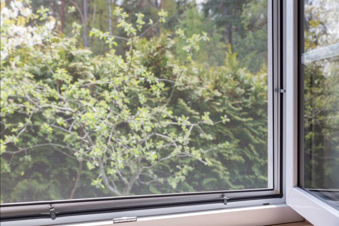 window with mosquito screen and green garden view Corfu greece